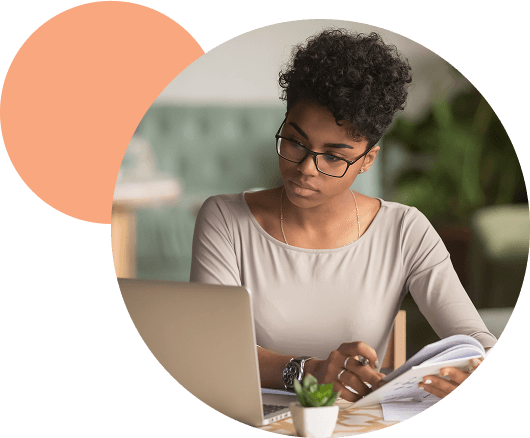 Une femme basané regarde sont portable en prennant des notes